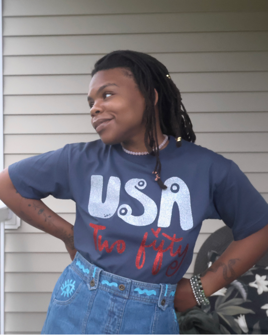 Person wearing a 'USA' t-shirt on a porch with a grassy field in the background